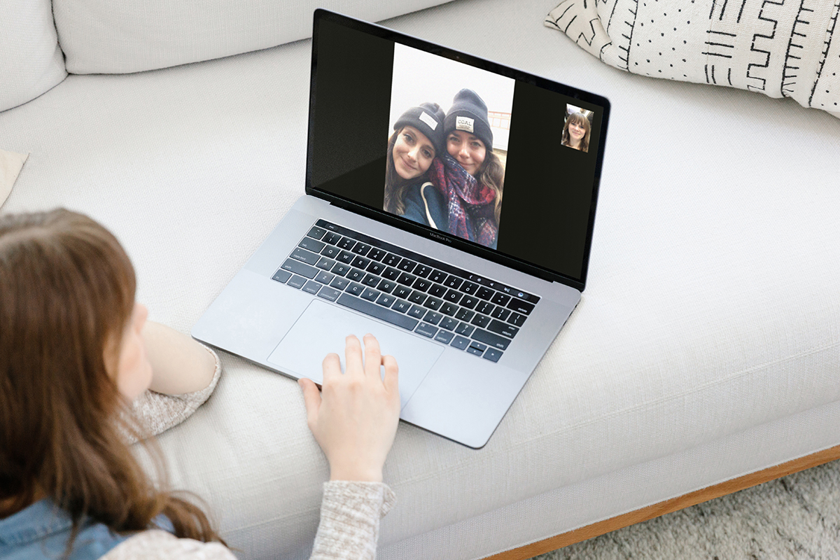 Woman video chatting with friends on laptop