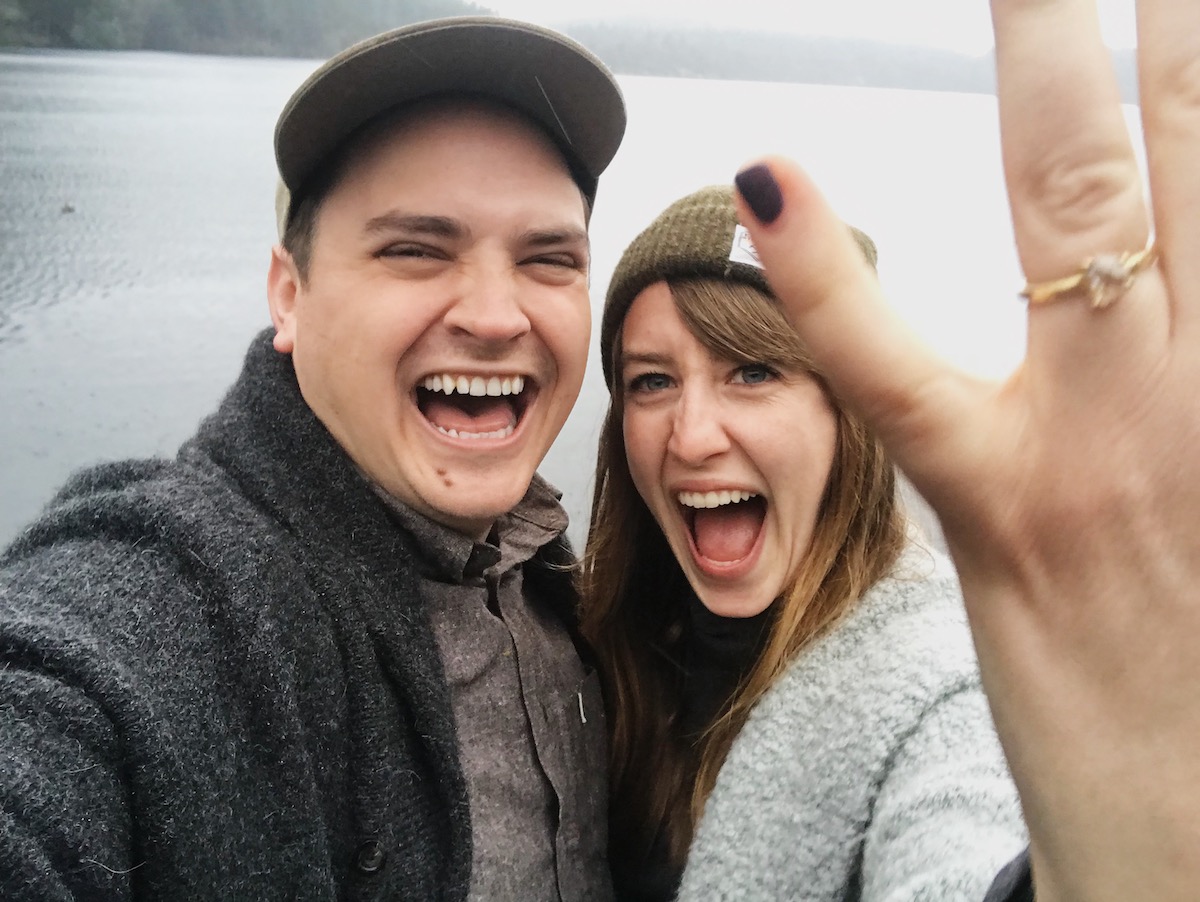 Selfy of newly engaged couple with woman holding up ring
