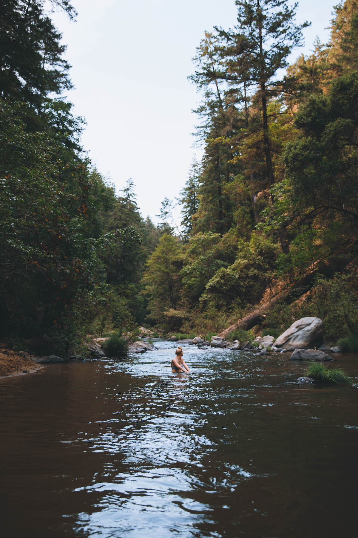Young woman in a river taking in the scenic views