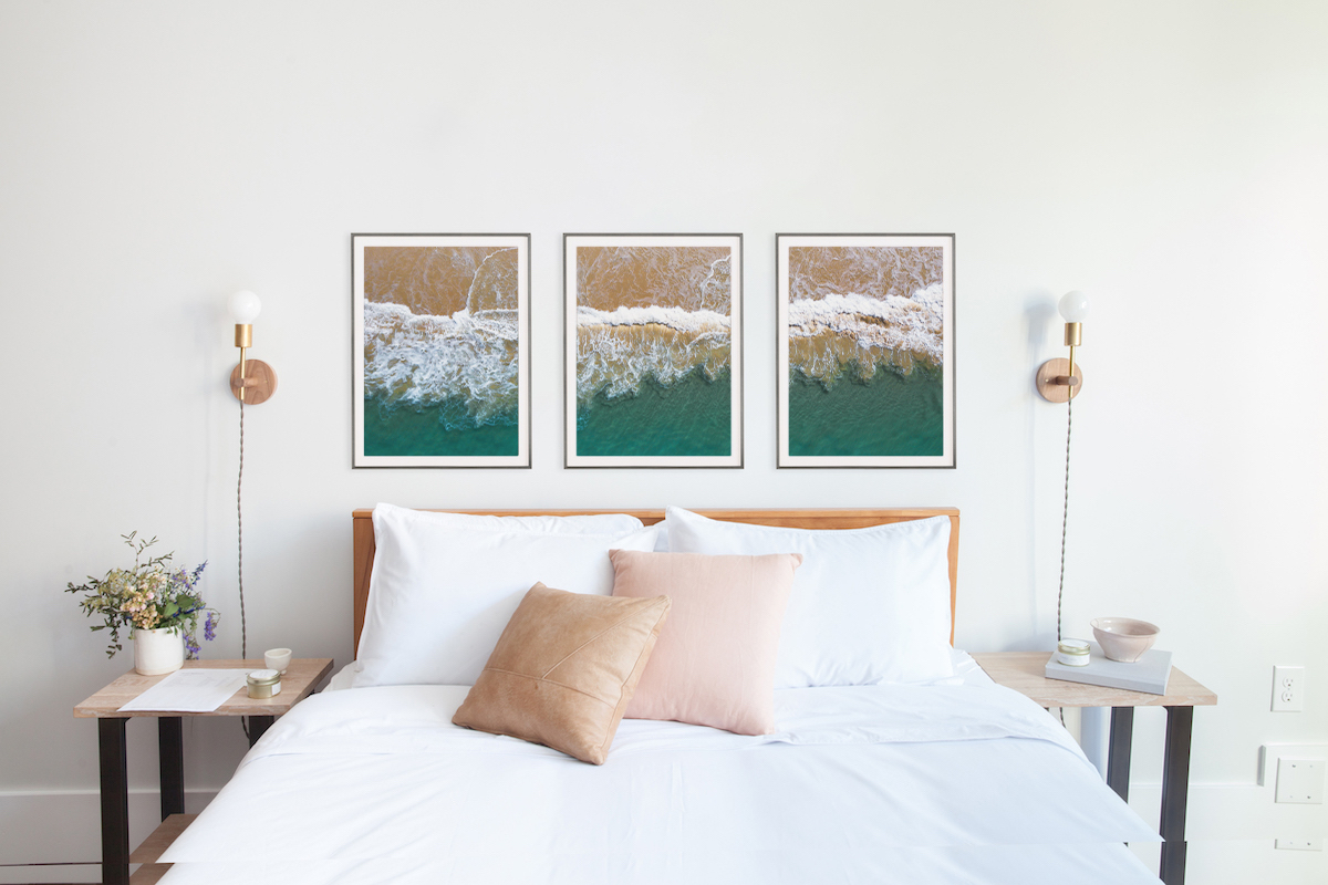 Panoramic photo split into three frames hanging above bed