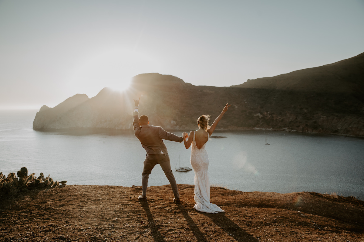 Couple celebrating by the water at golden hour