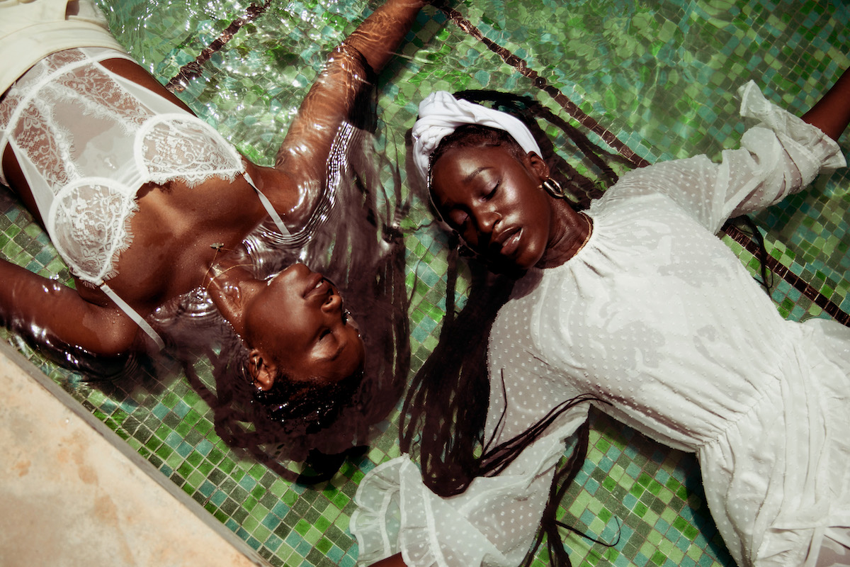 Photo by Andre L. Perry of two Black women laying side by side in water