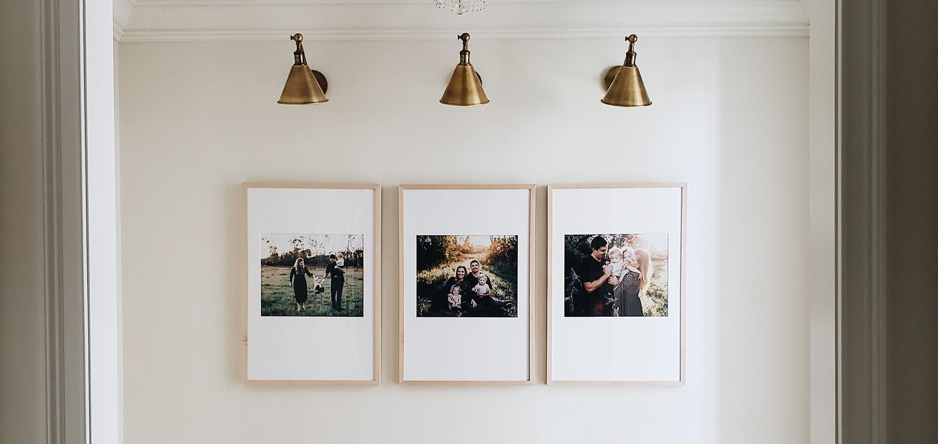 Three large framed family photos hung side by side