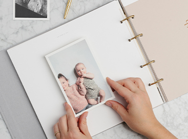 Hands placing photo on page of Story of You Baby Book
