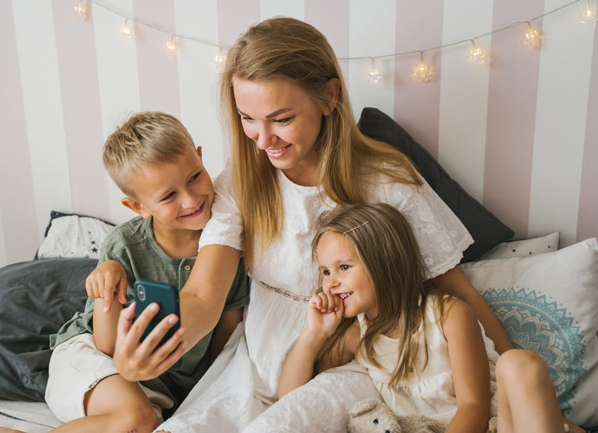 mother and two young children video chatting with family