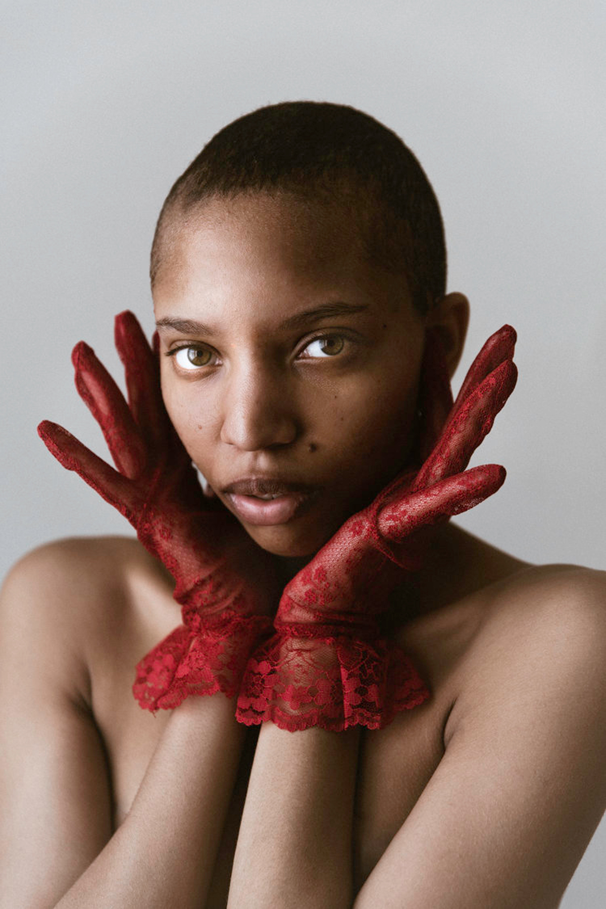 Portrait of young woman wearing red gloves by Molly Olwig