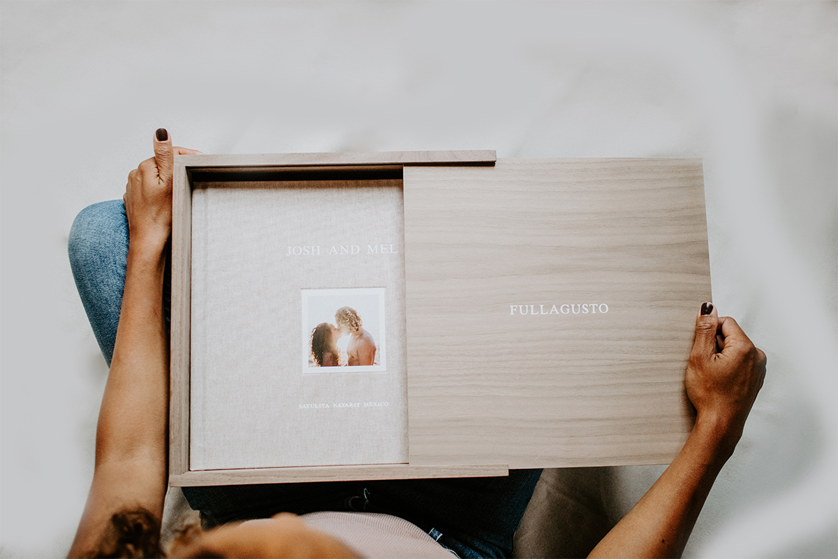 Woman placing Signature Layflat Album in walnut storage box