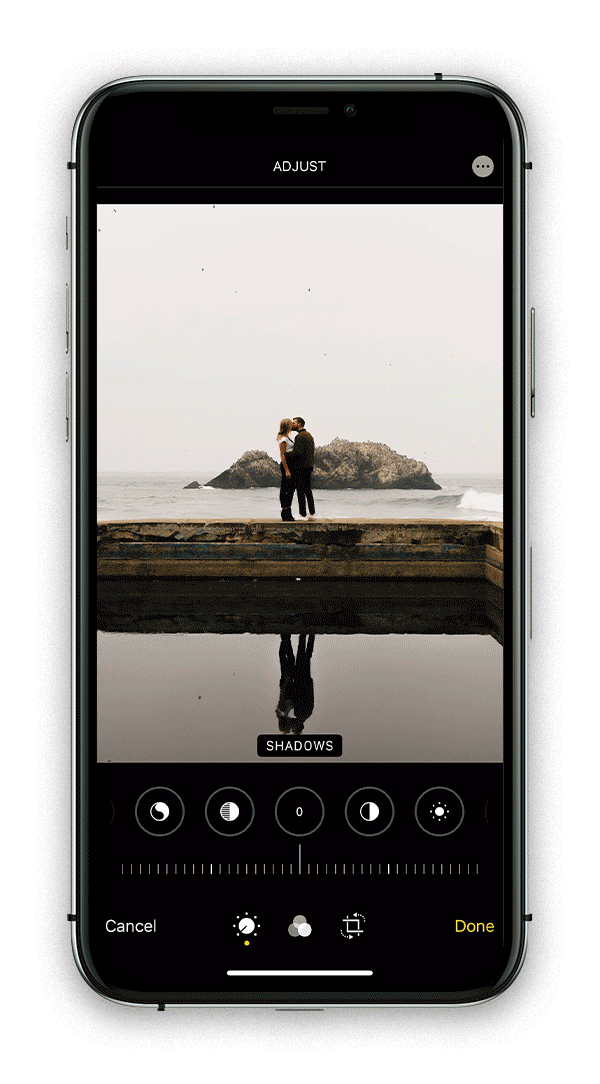 Adjusting shadows in iphone native photo editor to edit a photo of a couple kissing on the coast 
